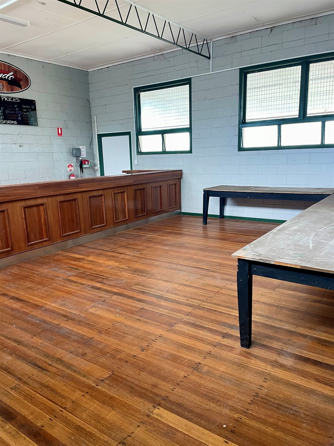 Interior of Killarney Pavilion showing timber floors, bar counter, long work tables, and windows providing natural light