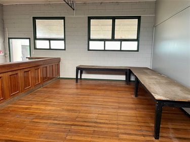 Interior of Killarney Pavilion showing timber floors, bar counter, long work tables, and windows providing natural light.