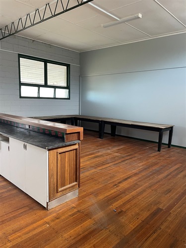 Interior of Killarney Pavilion showing timber floors, bar counter with cabinetry, long work tables, and windows providing natural light.